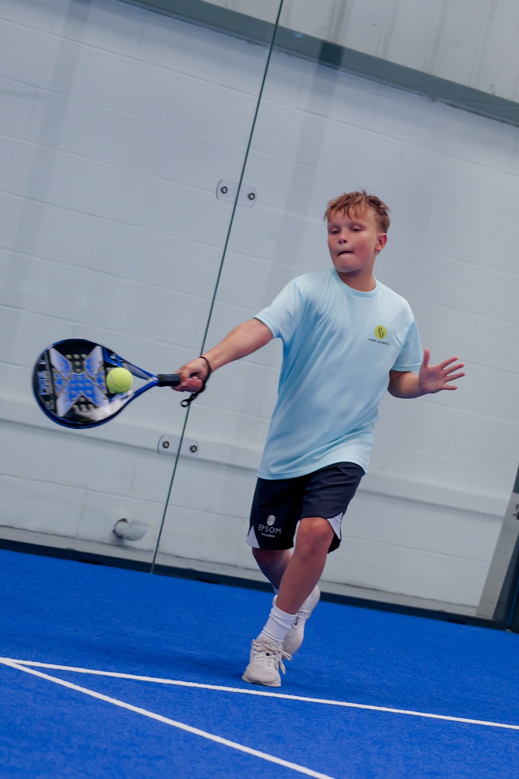 A junior player hitting a forehand at Padel Quarter