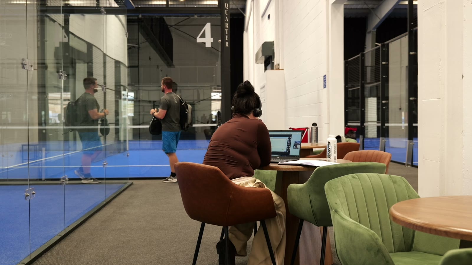 Players relaxing beside court four at Padel Quarter